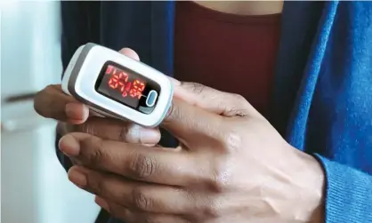  ?? Photograph: Grace Cary/Getty Images ?? Pulse oximeter measure oxygen in bloodstrea­m. Low levels can be a sign of worsening Covid.