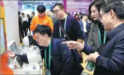  ?? FENG YONGBIN / CHINA DAILY ?? A visitor examines an exhibitor’s healthcare product at the expo in Shanghai on Tuesday.