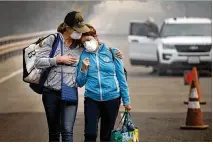  ?? RANDY PENCH / THE SACRAMENTO BEE ?? Colby Clark of San Francisco (left) comforts her mother, Bonnie Trexler, on Wednesday after Trexler was escorted to her home in Napa, Calif., to retrieve personal items.