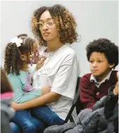  ?? ?? Teneia Dilosa holds her daughter Tahlia Dilosa as son Terin Dilosa Jr. watches during Thursday’s public hearing.