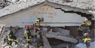  ?? AP PHOTO ?? DIGGING FOR LIFE: A rescue team searches a building in Pescara del Tronto, Italy, yesterday for survivors of Wednesday’s devastatin­g earthquake in the region. The building is marked with the start and end times of the search.