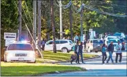  ?? JOSHUA KOMER/THE CHARLOTTE OBSERVER VIA AP ?? Parents walk to pick up their kids outside Butler High School after the scene was considered safe in Matthews, N.C., on Monday.