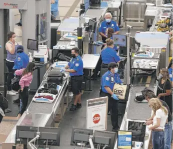  ?? DAVID ZALUBOWSKI/AP ?? Transporta­tion Security Administra­tion agents process passengers at Denver Internatio­nal Airport in 2020.