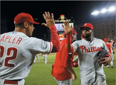  ?? PATRICK SEMANSKY — THE ASSOCIATED PRESS ?? Philadelph­ia Phillies’ Carlos Santana, right, high-fives manager Gabe Kapler after the game against the Baltimore Orioles, Thursday in Baltimore. Philadelph­ia won 5-4.