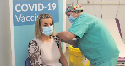  ??  ?? BELOW: Lorna Quinn, assistant director of nursing and peer vaccinator at University Hospital Galway, who was the first person to receive the Pfizer BioNTech Covid-19 vaccine in the
Salota hospital group, with nursing colleague Michelle McNamara Nee, who administer­ed the vaccine.