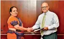  ??  ?? Malik Wickramana­yake-Deputy General Manager, Operations exchanging the agreement with Nalani Malkanthi Bandara, Superinten­dent EPF Department of CBSL.