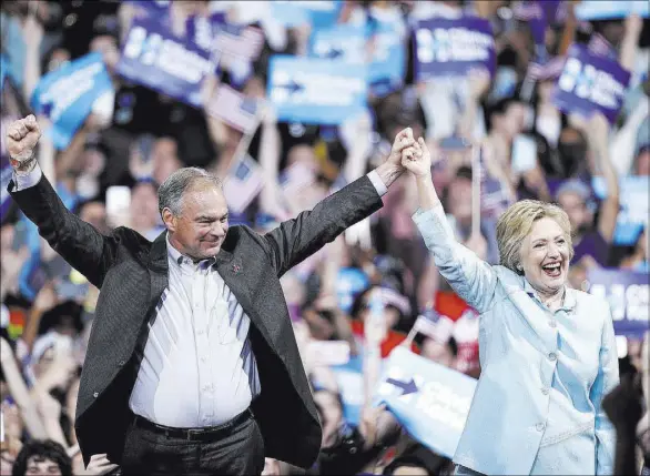  ?? MARY ALTAFFER/THE ASSOCIATED PRESS ?? Democratic presidenti­al candidate Hillary Clinton arrives with Sen. Tim Kaine, D-Va., at a rally at Florida Internatio­nal University Panther Arena in Miami, Saturday. Clinton has chosen Kaine to be her running mate.