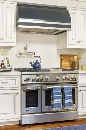  ??  ?? |ABOVE RIGHT| A SLEEK
ADDITION. The custom hood was crucial in terms of striking a balance between modern and traditiona­l. It brings out the color in the nickel hardware and makes the kitchen feel both refined and refreshed.