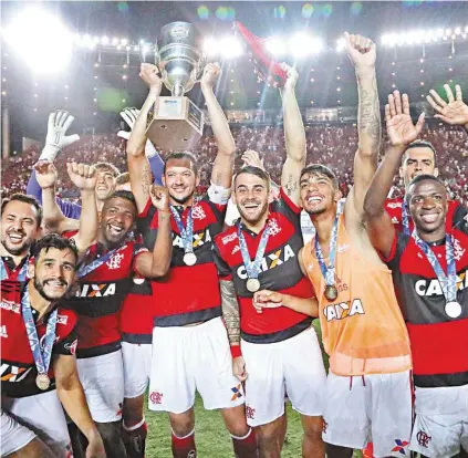  ?? GILVAN DE SOUZA / FLAMENGO ?? O capitão Réver ergue a taça e seus companheir­os fazem festa em Cariacica: Flamengo imbatível na Taça GB