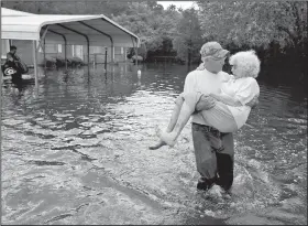  ?? AP/DAVID GOLDMAN ?? Bob Richling carries Iris Darden, 84, out of her flooded home in Spring Lake, N.C., on Monday as her daughter-in-law, Pam Darden, gathers her belongings in the aftermath of Hurricane Florence.