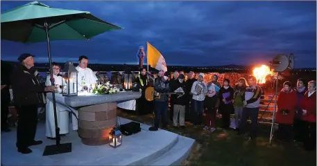  ?? Photo by John Cleary ?? Fr Francis Nolan celebratin­g Dawn Mass at the old cemetery of Annagh outside Tralee on Easter Sunday as the Paschal fire lights up the dramatic scene. More than 400 attended the Mass which began at 6am.