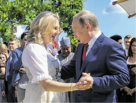  ?? BILD: SN/AP ?? Außenminis­terin Karin Kneissl und Russlands Präsident Wladimir Putin.