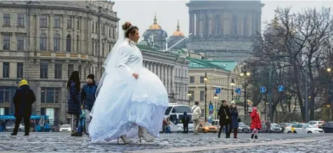  ?? Foto: Dmitri Lovetsky, dpa ?? Eine Braut geht über den Schlosspla­tz in St. Petersburg. In Russland finden derzeit viele Trauungen statt, damit Paare zumindest ein Recht auf Informatio­nen haben, sollte der Partner im Krieg verletzt werden.