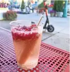  ?? MILWAUKEE JOURNAL SENTINEL ?? Why, yes, that really is a frozen pop in that drink from Sneaky Pete’s Poptails outside the Milwaukee Public Market. Specifically, it’s a peach Bellini with a peach pop in prosecco, garnished with frozen raspberrie­s.