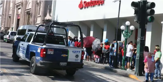  ?? YAZMÍN SÁNCHEZ ?? Elementos de la PEA custodian las filas en los bancos, donde se está pagando becas.