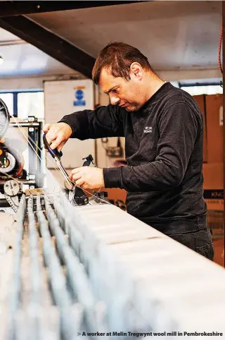  ?? ?? > A worker at Melin Tregwynt wool mill in Pembrokesh­ire