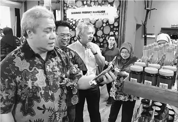  ??  ?? Awang Tengah takes a closer look at one of the food products on display at SPP.