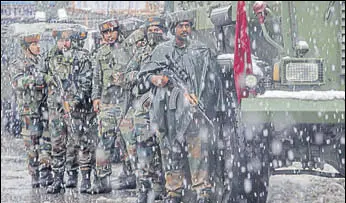  ?? AP PHOTO ?? Army personnel take up position as it snows at the site where two gunmen opened fire near a paramilita­ry camp in Srinagar on Monday.