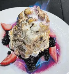  ?? DIANE GALAMBOS PHOTO ?? Baked Alaska: ice cream on a chocolate biscuit, covered with torched meringue and aflame with Grand Marnier pour-over.