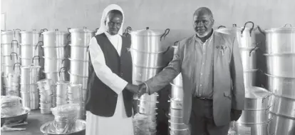  ??  ?? Founder of the General Foundation Apostolic Church in Christ Doctor Francis Jinoti Moyo hands over kitchen utensils