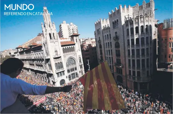  ??  ?? ► Un hombre sostiene una bandera catalana, ayer en Barcelona.