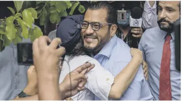  ??  ?? 0 Felix Maradiaga hugs a supporter outside the attorney general’s office. He was arrested later