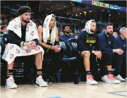  ?? CARLOS AVILA GONZALEZ/AP ?? Golden State Warriors Klay Thompson (11), Jordan Poole (3), and Stephen Curry (30) watch from the bench during the second half of Game 5.