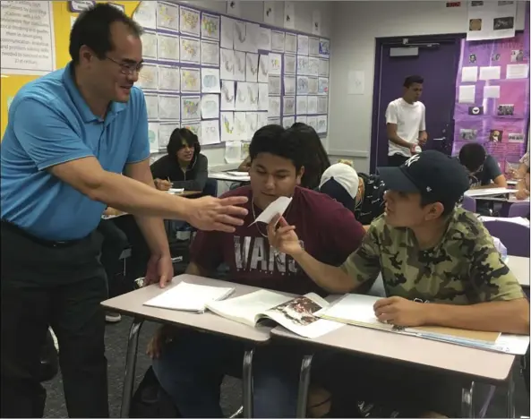  ?? ALYSSA VILORIA PHOTO ?? Mexican American History teacher Michael Hsu helps a couple of students understand their notes in class at Southwest High School.