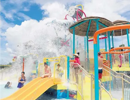  ?? AMY BETH BENNETT/SOUTH FLORIDA SUN SENTINEL ?? A 550-gallon dump bucket showers people below at Safari Falls Splash Park at Lion Country Safari in Loxahatche­e. Attraction is open daily, weather permitting and is included in park admission.