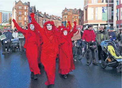  ?? ?? Extinction-Rebellion-Mitglieder beim Klimagipfe­l im schottisch­en Glasgow. Die Bewegung fällt oft mit Störaktion­en auf, aber auch mit künstleris­chem Protest oder mit bunten, meist blutroten Gewändern.