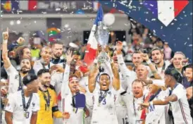  ?? AFP ?? French players celebrate with the trophy after beating Spain in the Nations League final at San Siro stadium in Milan on Sunday.