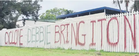  ??  ?? A sign can be seen painted on the fence of a home regarding the arrival of Cyclone Debbie in the northern Australian town of Bowen, located south of Townsville in Australia. — Reuters photo