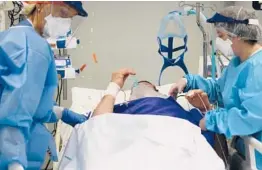  ?? ANTONIO CALANNI/AP ?? Hospital workers tend to a patient Thursday in Pope John XXIII Hospital’s COVID-19 intensive care unit in Bergamo, Italy.