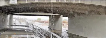  ?? Signal file photo ?? The Santa Clara River wash flows with muddy water during a storm. The Santa Clarita Valley Water Agency is considerin­g a deal with a Ventura County agency to manage the river’s watershed.