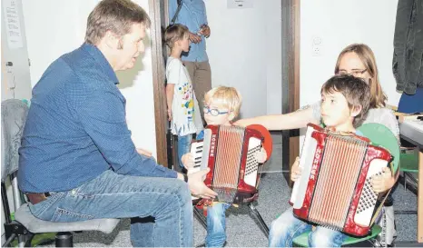  ?? SZ-FOTOS (2) : KURT EFINGER ?? Musikinstr­umente zum Tönen zu bringen bereitete Kindern Freude.Bei Ulrich Kruspel probierten zwei Buben Akkordeons aus.