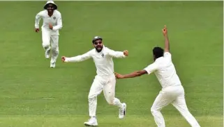  ?? – AFP ?? OVERJOYED: India’s captain Virat Kohli and bowler Ravichandr­an Ashwin cleberate India’s victory against Australia in the first Test cricket match at the Adelaide Oval.