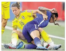  ?? JOHN WOODS / CANADIAN PRESS ?? Sweden’s Lina Nilsson (left) hauls down U.S. player Sydney Leroux during the second half of the World Cup Group D match in Winnipeg. The U.S. could have advanced with a win.