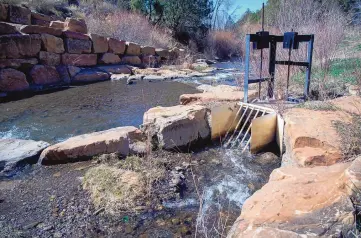  ?? EDDIE MOORE/JOURNAL ?? Water flows through a diversion that sends one-third of the water to the Acequia del Monte in Talpa.