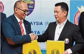  ?? — GLENN GUAN / The Star ?? Done deal: BAM president Datuk Seri Norza Zakaria (right) exchanging documents with UM deputy vicechance­llor (developmen­t) Prof Dr Faisal Rafiq Mahamd Adikan after the MoU signing ceremony in Bukit Kiara yesterday.