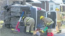  ?? JASON BAIN/EXAMINER ?? City firefighte­rs move items from a minivan that ended up on its side on the lawn of a house after a collision with a car at Bethune Street and Aberdeen Avenue at about 9:15 a.m. Wednesday.
One person from each vehicle were freed from the wreckage by...