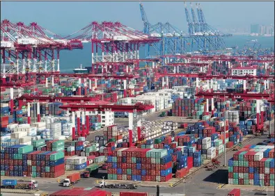  ?? AP ?? Containers sit piled high Thursday at a port in Qingdao, China. China’s export growth accelerate­d in October as companies rushed out shipments before new U.S. tariff rates kick in.