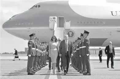  ?? AP Photo/Pablo Martinez Monsivais ?? ■ U.S. President Donald Trump and first lady Melania Trump walk across the tarmac Thursday after stepping off Air Force One as they arrive at London’s Stansted Airport. Walking directly behind them is Woody Johnson, center, United States Ambassador to...