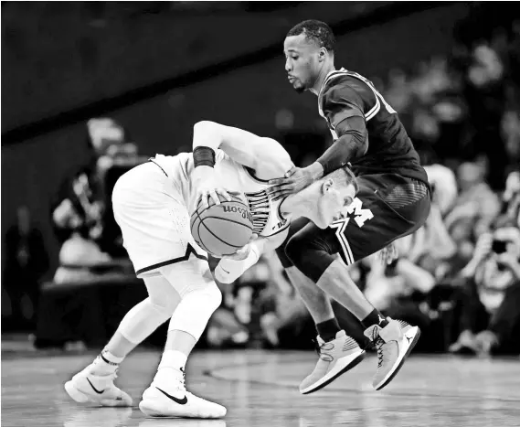  ?? BOB DONNAN/USA TODAY SPORTS ?? Villanova reserve guard Donte DiVincenzo, battling Michigan’s Muhammad-Ali Abdur-Rahkman, scored a game-high 31 points in the NCAA title game, a 79-62 Wildcats victory.