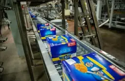  ?? TNS via Getty Images ?? Packages of Easy Mac Macaroni & Cheese Cups move along the production line at a Kraft Heinz manufactur­ing plant.