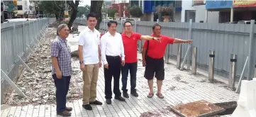  ??  ?? (From left) Dr Bob, Ling, Dr Ting, Hii and a DAP member at the site of the Miri Wireless Walk. Hii and the DAP member are pointing at the fencing that visually blocks the cafes and restaurant­s from the view of the public.