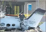  ?? JAE C. HONG — THE ASSOCIATED PRESS ?? An investigat­or on Monday surveys wreckage of an aircraft that crashed Sunday, killing all five aboard.