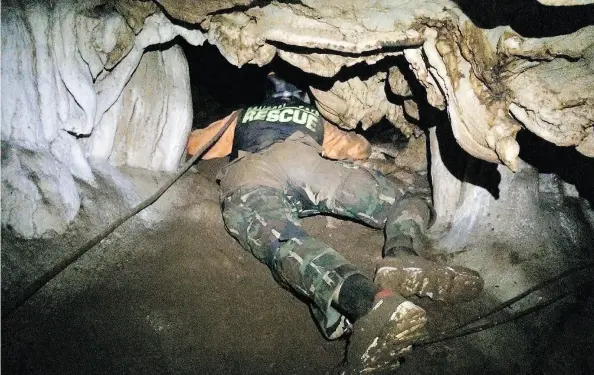  ?? THAILAND DEPARTMENT OF NATIONAL PARKS AND WILDLIFE VIA THE ASSOCIATED PRESS ?? Rescue personnel search for alternate entrances. The missing boys were eventually found by Rick Stanton and John Volanthen, below left.