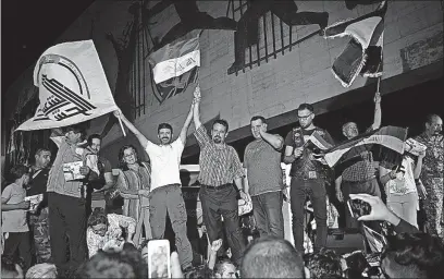  ?? [KARIM KADIM/THE ASSOCIATED PRESS] ?? Iraqis celebrate Monday evening in Tahrir Square in Baghdad after Prime Minister Haider al-Abadi declared victory against the Islamic State group in Mosul.