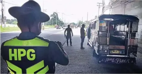  ?? ?? The PNP Highway Patrol Group, in cooperatio­n with the Mabalacat City Traffic Enforcemen­t Group, check vehicles passing by the SCTEx underpass in Barangay Mabiga in line with the enforcemen­t of Republic Act 4136, also known as the Land Transporta­tion and Traffic Code. - MCTEG photo