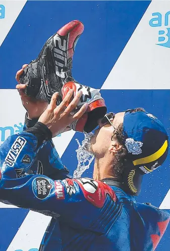  ?? Pictures: AFP ?? Suzuki Ecstar's Spanish rider Alex Rins drinks from his driving boot on the podium after winning the Australian MotoGP at Phillip Island on Sunday and (below) Aussie Jack Miller crashes with Spanish rider Alex Marquez.